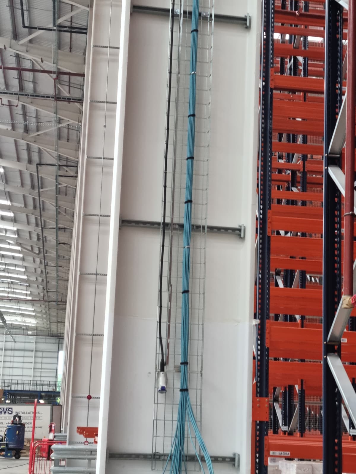 Cable riser route, warehouse install with orange racking